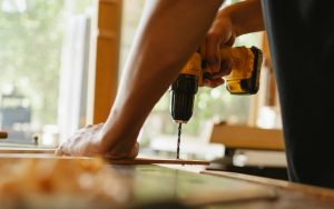 man drilling into a piece of wood