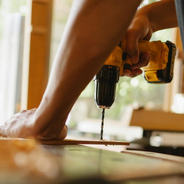 man drilling into a piece of wood