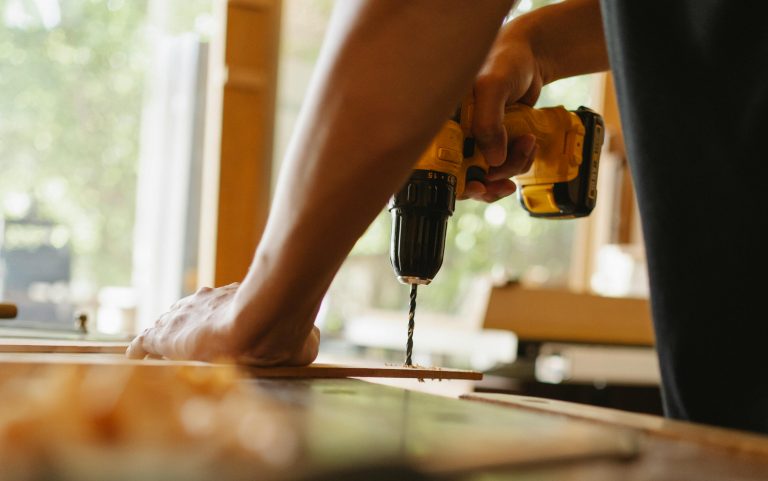 man drilling into a piece of wood